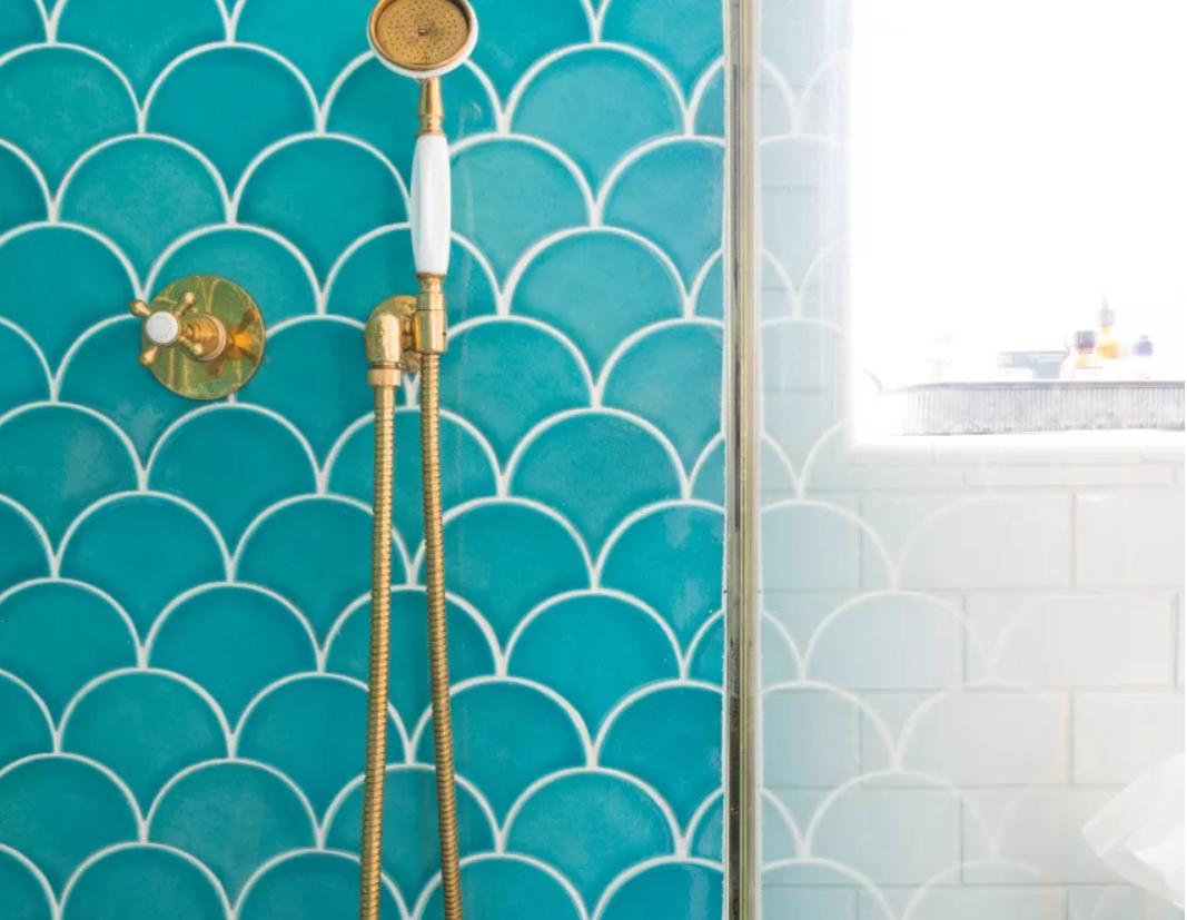 Bright aqua Fish scale pattern tile in a shower with brass fixtures