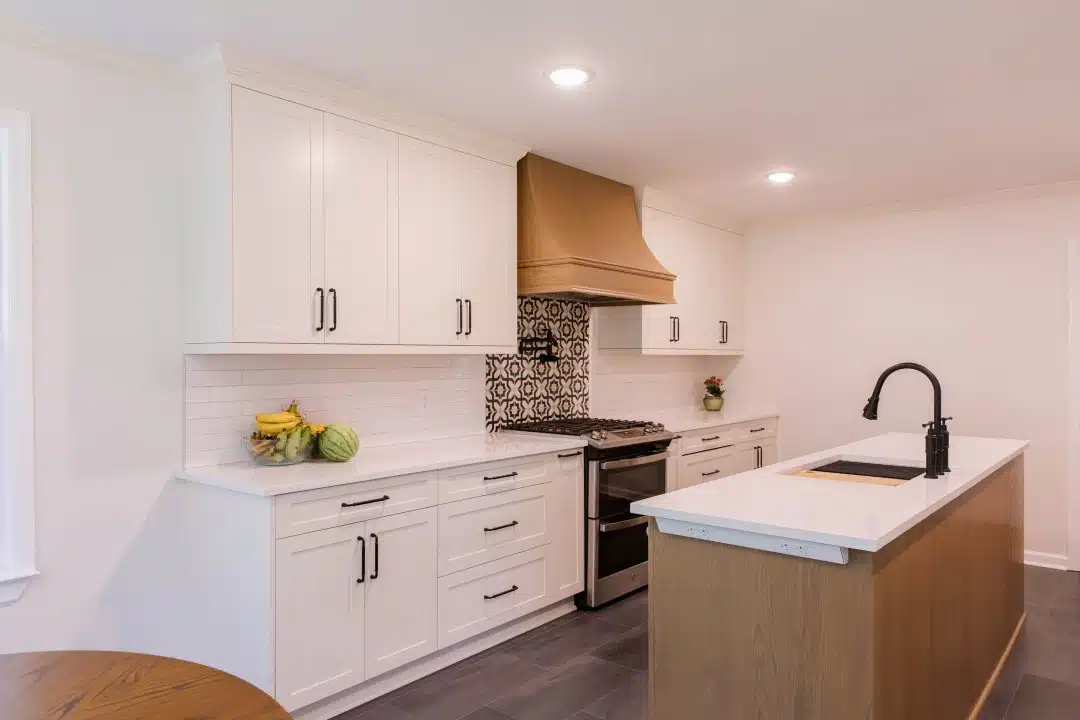 Framily Kitchen featured photo with wood hood, decorative tile, matching island and white perimeter cabinet