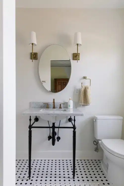 Small bath vanity with marble top and gold sconces