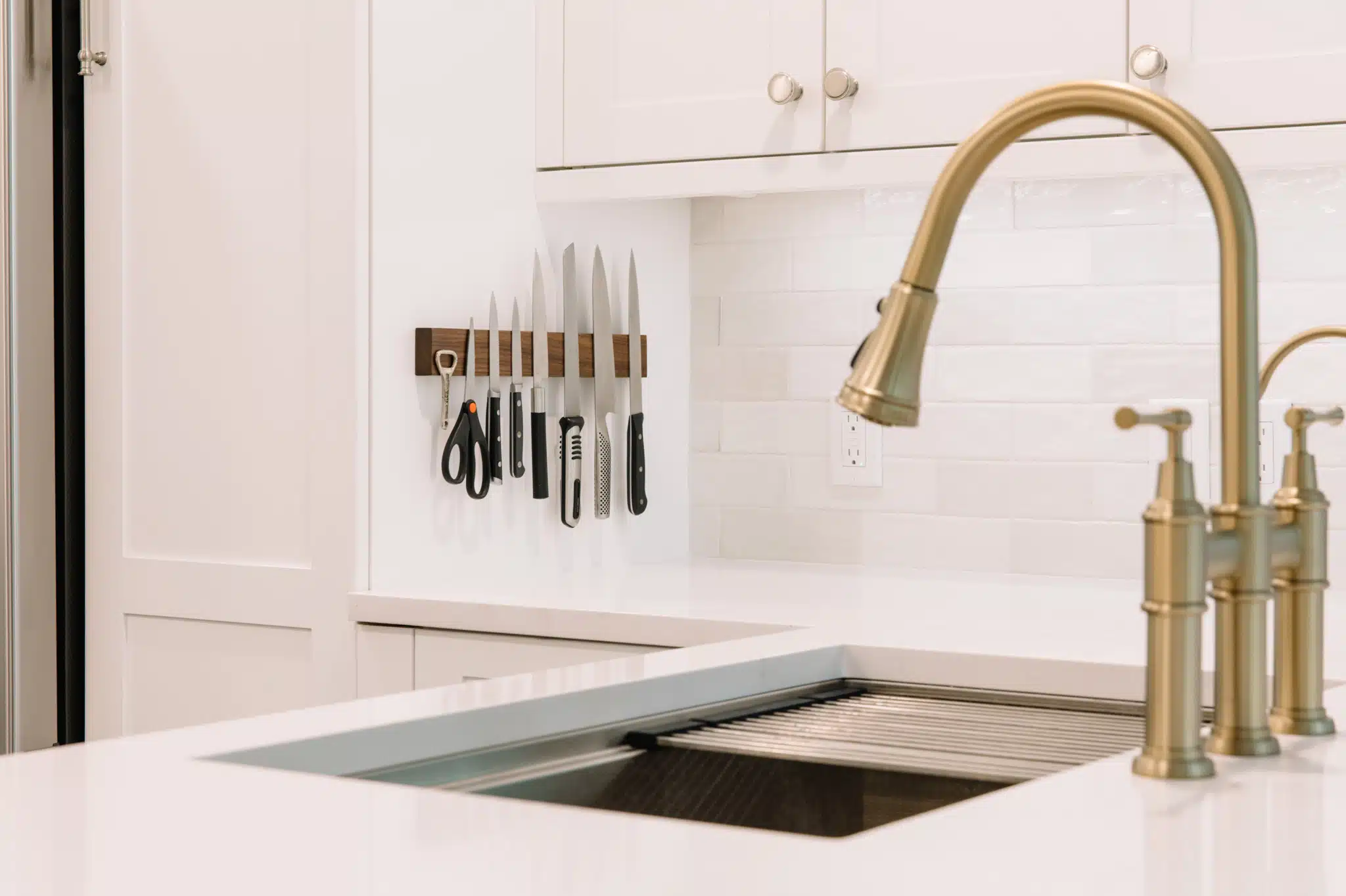 Bridge faucet in Gold in a contemporary white kitchen 